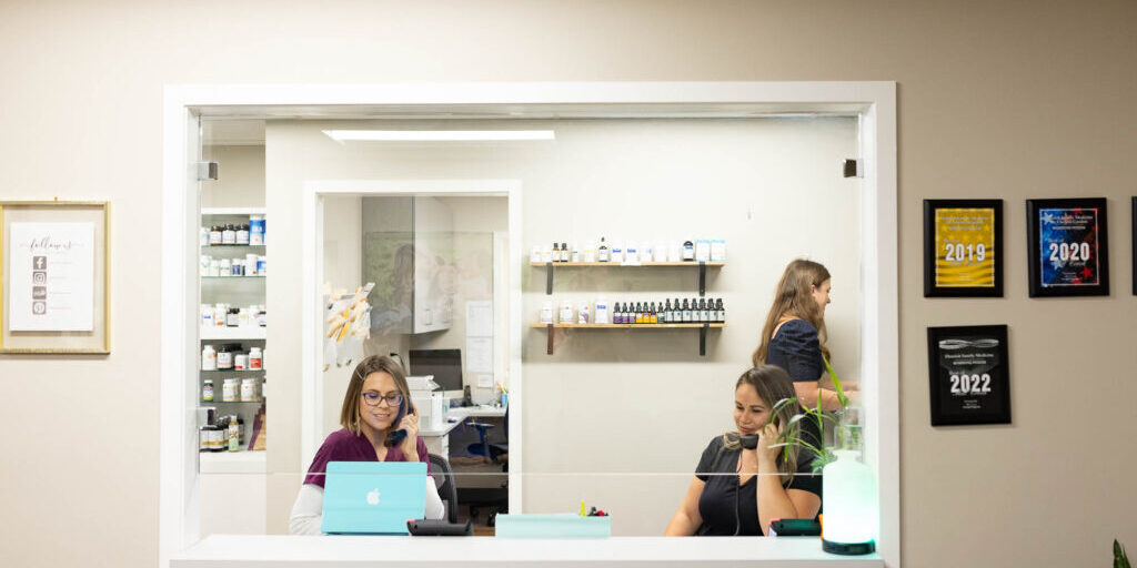 Photo shows several individuals working at the reception desk in the office.